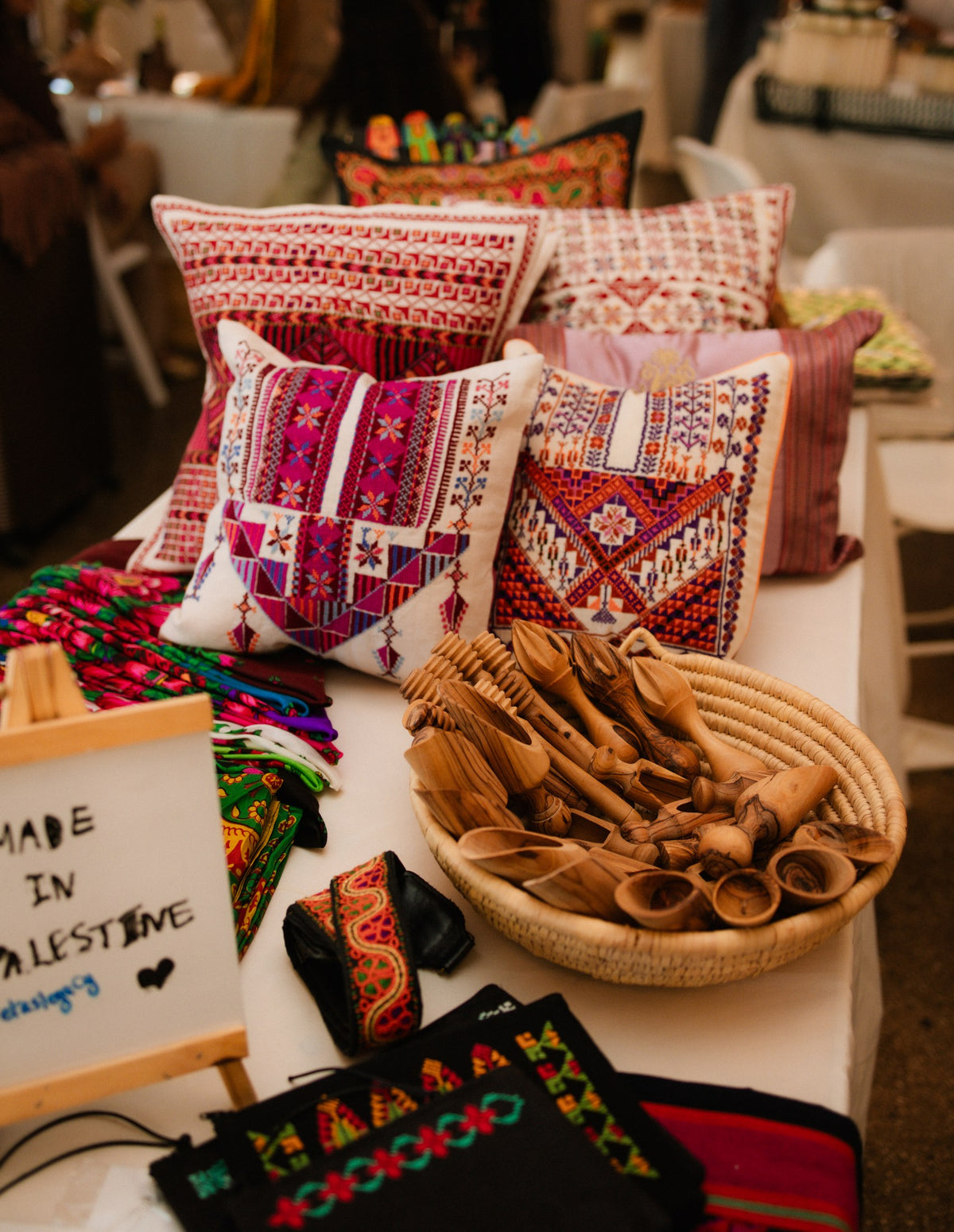 Embroidered textiles and carved wooden crafts displayed at a cultural gathering